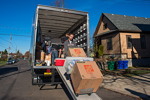 Movers unloading boxes down a ramp